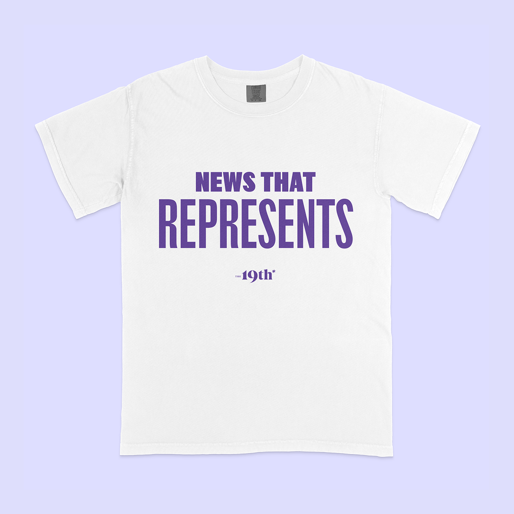 A white short-sleeve crewneck t-shirt with purple text reading 'News That Represents, The 19th*' printed on the front, displayed flat against a light lavender background.